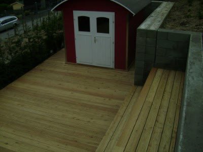 Terrasse aus sibirischer Lärche vor einem Gartenhaus