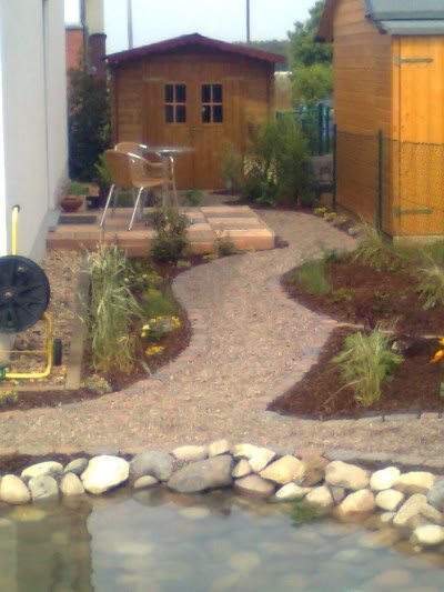 Weg zum Gartenhaus mit Staudenbeet